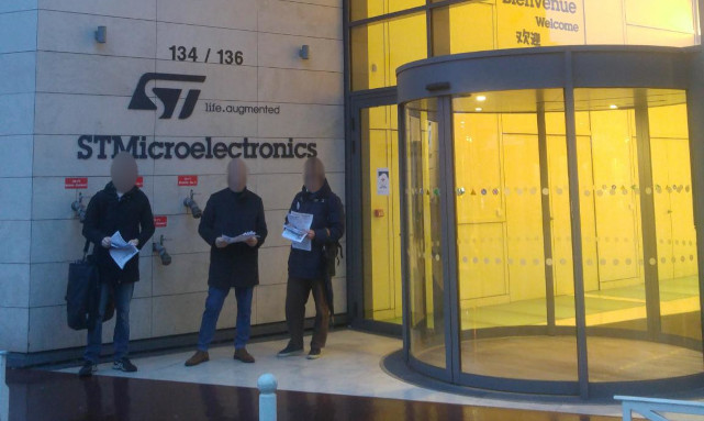 Trois personnes tractant devant les locaux de STMicroelectronics